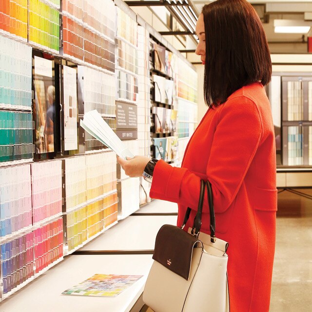 Several customers explore colour options in a Benjamin Moore store.
